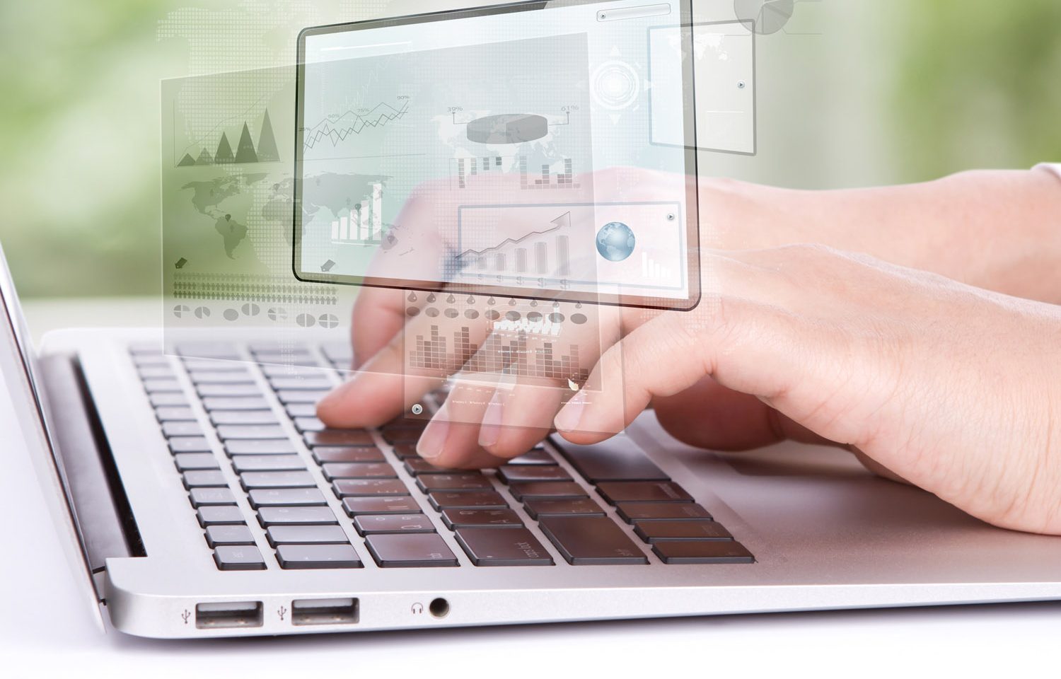 Hands typing on laptop with overlay of screen, world maps, and charts and analysis