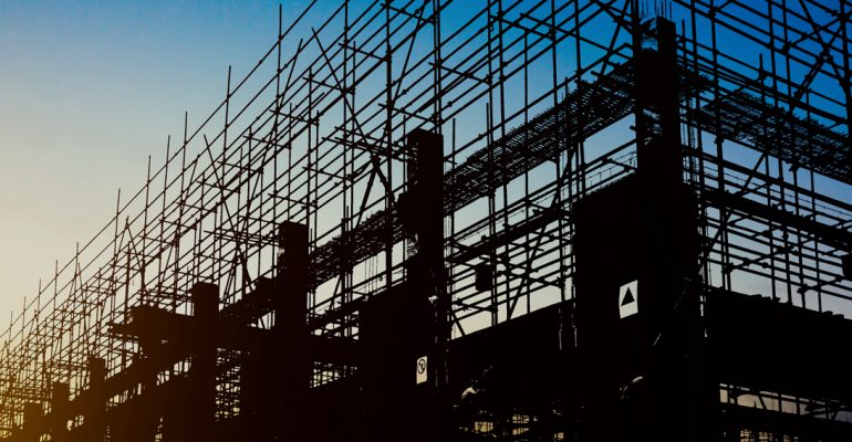 Construction side scaffolding with sunrise in background